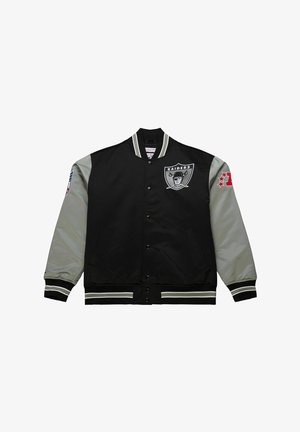Chaqueta varsity Raiders negra y gris con botones de presión delanteros, cuello y puños a rayas, logo del equipo en el pecho y parches en ambas mangas.