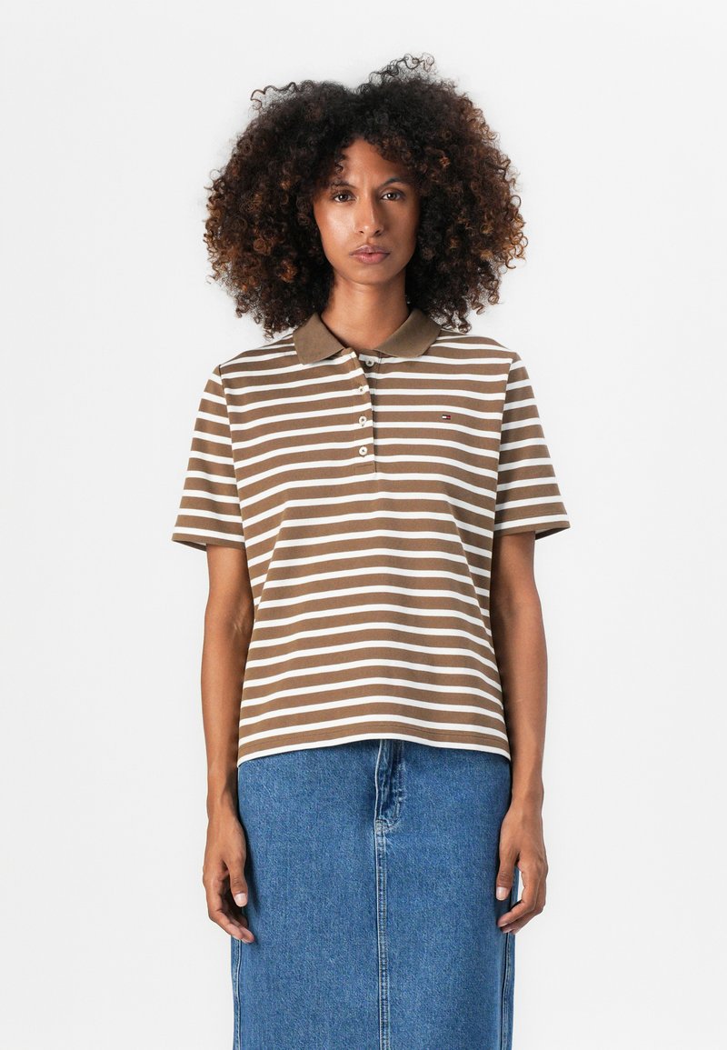 Brun og hvit stripete polo-skjorte med krage, med en tre-knappslukking og en liten logo på brystet. Båret med et denim-skjørt.