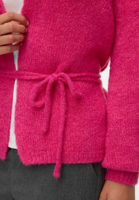 Cardigan fuchsia avec un tricot texturé, devant ouvert, manches longues et une ceinture nouée à la taille. Tissu doux et confortable avec une finition chaude et homogène.