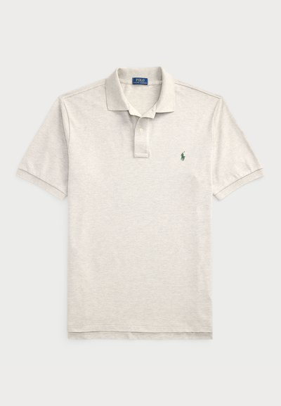Polo de cor cinza claro feito de algodão, com uma pala de três botões, mangas curtas e um pequeno logo verde no lado esquerdo do peito.