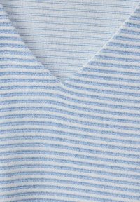 Ljusblå och vit randig tyg med V-ringning; texturen verkar mjuk och stickad, med jämnt fördelade horisontella linjer.