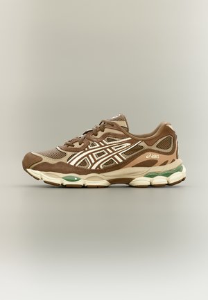 Brązowy i beżowy but biegowy ASICS z siateczkową i zamszową cholewką, odblaskowymi paskami, amortyzowaną podeszwą i zielonymi akcentami żelowymi na podeszwie zewnętrznej.