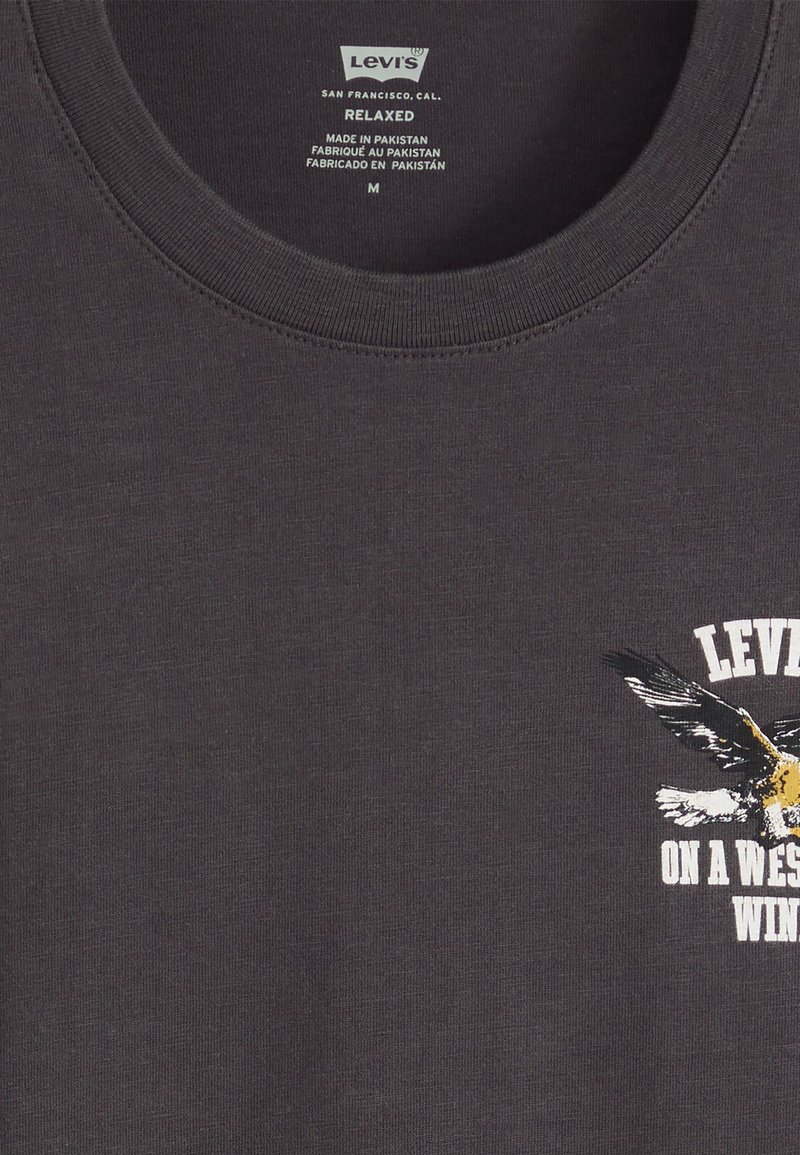 T-shirt en coton gris foncé avec un col rond, coupe décontractée et un graphique en façade représentant un aigle avec le texte "LEVI'S ON A WEST WIND."