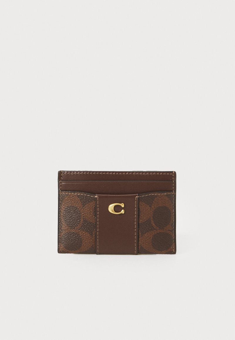 Brown leather card holder with embossed circular pattern, gold hardware, and multiple card slots. Compact design with smooth and textured surfaces.
