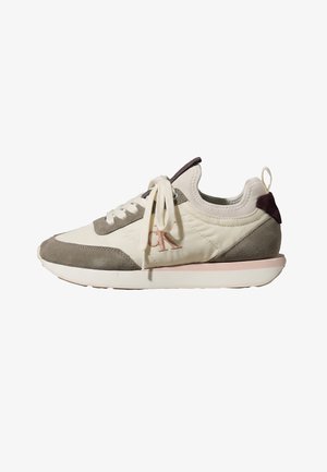 Niski sneaker z kremowej tkaniny, szare akcenty ze zamszu, białe sznurowadła, różowa obwódka podeszwy i pętelka przy pięcie.