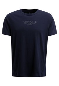 Námorně modré tričko s krátkým rukávem a kulatým výstřihem, které má uprostřed na hrudi světle šedý nápis "Armani Exchange Icon".