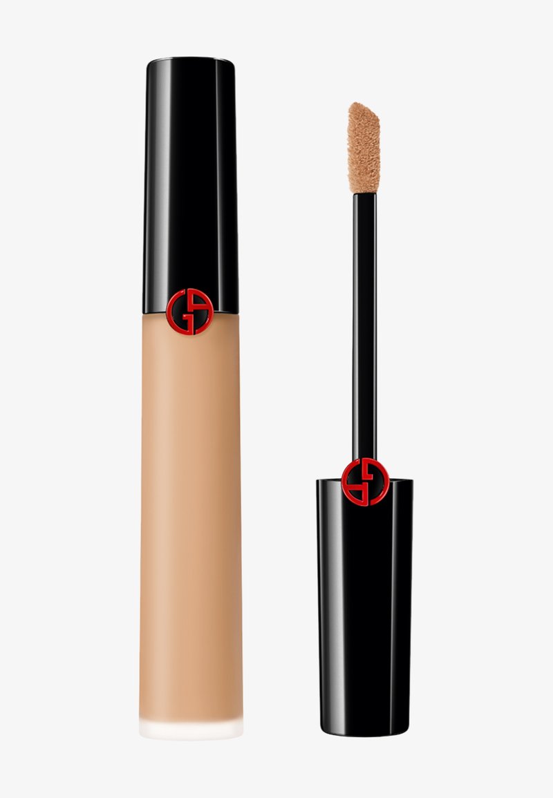 Base líquida en un tubo transparente con una tapa negra que presenta un emblema rojo. Cuenta con un aplicador tipo varita con una punta suave y redondeada.