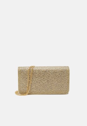 Goldene Clutch-Tasche, bedeckt mit kleinen Perlen und Perlen, mit einem goldenen Kettenriemen vor einem schlichten Hintergrund.