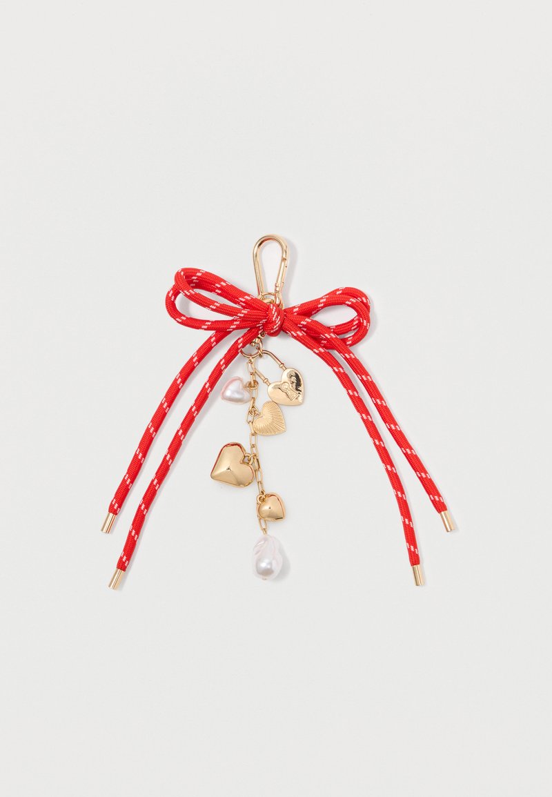 Red ribbon bow with a gold clip, featuring dangling gold hearts and a pearl accent. The ribbon has white stripes and finials.