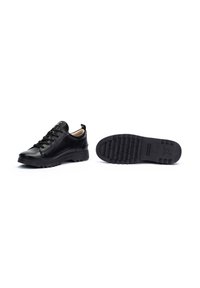 Chaussures en cuir noir avec un bout arrondi, un laçage et une semelle texturée. Présentent un talon robuste et une doublure intérieure lisse.