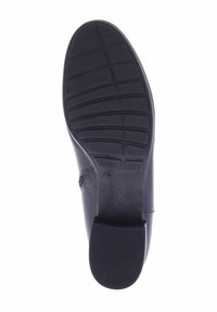 Suela de zapato negra con una superficie de goma texturizada. Presenta un patrón de banda de rodadura prominente y un área del talón lisa. La marca es visible en el lado.
