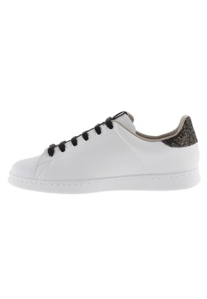 Sneaker bianco con lacci neri, tomaia in sintetico liscio, punta arrotondata e accento sul tallone dorato glitterato texturizzato. Suola in gomma per una buona aderenza.