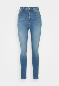 Jeans ajustados de tiro alto en denim azul. Presentan una textura suave, áreas descoloridas, diseño de cinco bolsillos, cierre de botón metálico y pasadores para cinturón.