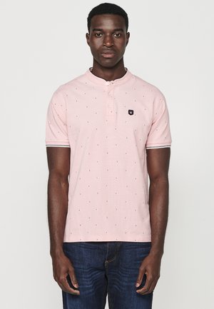 Roosa lühikeste varrukatega polo särk, millel on henley krae, musta logo plaat ja väikeste tumedamate kolmnurkade mustriga.