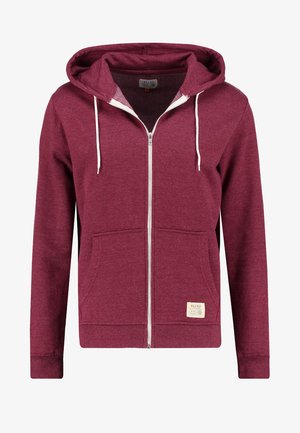 Bordo kapuco ar rāvējslēdzēju, ar auklu, priekšējām kabatām, ribinātām piedurknēm un mazu zīmola etiķeti apakšējā kabatas daļā.