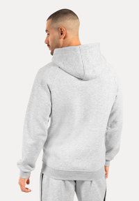 Sudadera gris con puños y dobladillo acanalados. Cuenta con una capucha espaciosa, hecha de material suave y presenta un acabado liso y texturizado.
