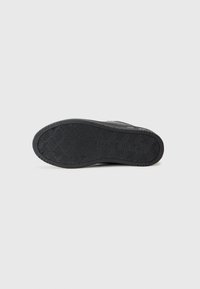Sola de sapato de borracha preta com padrão zigzag texturizado, apresentando a impressão "FEITO NA ITÁLIA". Bordas suaves e calcanhar moldado para estabilidade.