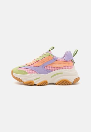 Masywne buty sportowe z pastelowo różową siateczką, lawendowymi i zielonymi nakładkami, pomarańczowymi akcentami, białą grubą podeszwą i zielonymi pętlami na pięcie i języku.