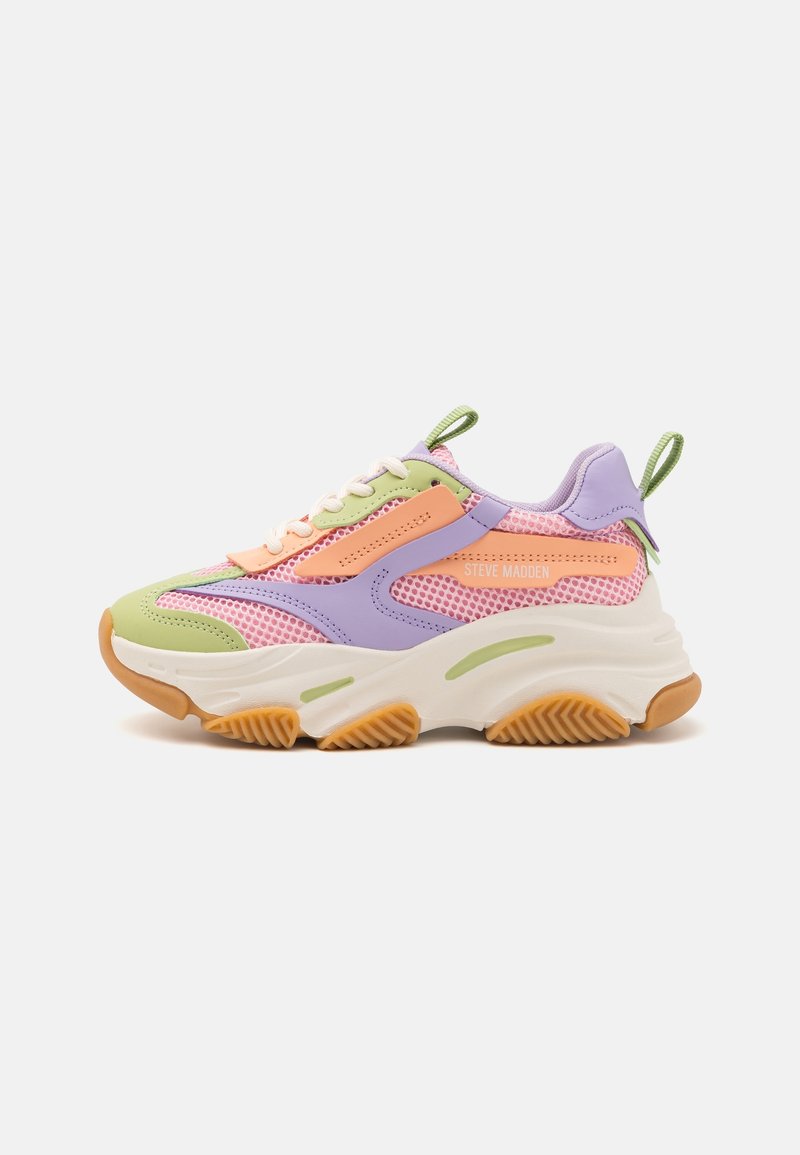 Sneakers épais avec mesh rose pastel, superpositions lavande et vertes, accents orange, semelle blanche épaisse et languettes vertes au talon et à la languette.
