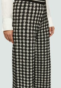 Zwart-witte geblokte wijde broek met een textuurstof, met een losse pasvorm en een hoge tailleband.