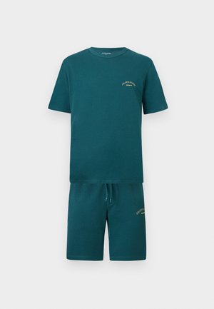 Türkisfarbenes T-Shirt mit kurzen Ärmeln und passendem Shorts-Set mit kleinem gelbem Textlogo auf der Brust und am linken Oberschenkel.