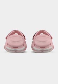 Ροζ αφρώδη παπούτσια με ανοιχτή πλάτη, με λευκή λαστιχένια σόλα και υφασμάτινο επάνω μέρος με υφή. Απλός σχεδιασμός με ρυθμιζόμενους ιμάντες στα πλάγια.