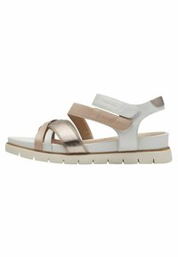 Sandales à lanières blanches et métalliques avec une semelle plate et épaisse. Elles présentent une combinaison de matériaux en rose doré brillant, beige et blanc texturé.