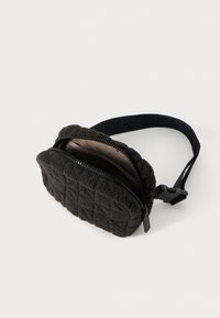 Geantă din material quilted negru, cu închidere cu fermoar, formă rotundă și curea detașabilă cu o cataramă plată. Interior în culoare contrastantă.