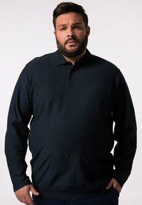 Tmavě modrá polo košile s dlouhým rukávem, texturovanými horizontálními pruhy, žebrovaným límečkem a manžetami, s volným střihem a knoflíkovou légou.