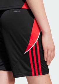 Svarta träningsshorts med röda detaljer, med en mjuk yta, vit pipning och tre vertikala röda ränder på sidan.