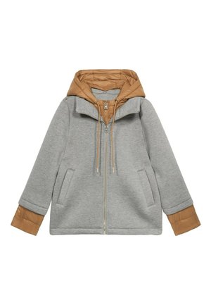 Giacca grigia con cappuccio trapuntato color carne, zip frontale, tasche laterali e polsini elasticizzati. Presenta un mix di materiali texturizzati.