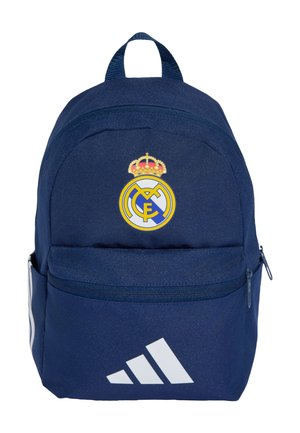 Mochila azul marino con el logo de Real Madrid centrado encima de un bolsillo frontal con cremallera y logo blanco de Adidas en la parte inferior delantera.
