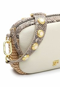 Borsa di pelle bianca con base tessuta testurizzata. Dotata di tracolla decorata con borchie dorate e chiusura con cerniera. Dettagli in metallo dorato.