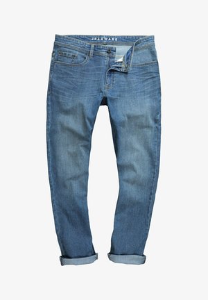 Farkut keskimääräisessä sinisessä sävyssä, haalistunut pinta, viisi taskua ja käännetyt lahkeet. Varustettu bränditunnuksella varustetulla vyötäröllä ja vetskarilla.