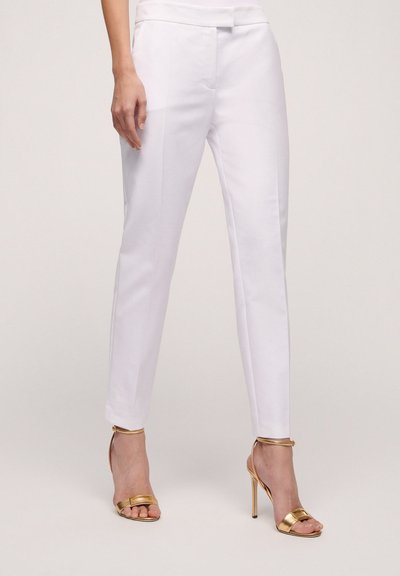 White tailored trousers with a slim fit, featuring a smooth texture and a subtle crease, paired with gold strappy high-heeled sandals.