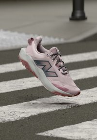 Ružičasti tenisica za trčanje s mrežastim gornjim dijelom, sivim detaljima i debelim, teksturiranim đonom. Povišen međupotplat, lagani dizajn i detaljno šivanje.