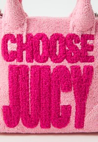 Ružová textúrovaná kabelka s vystúpeným, tučným nápisom: "VYBER SI JUICY" v tmavšej ružovej farbe. Dvoje krátke výčnelkové ušká na vrchu.