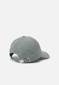 Boné de basebol cinza em algodão com uma aba curva, tira ajustável e fivela de metal. Apresenta um topo costurado e uma textura suave.