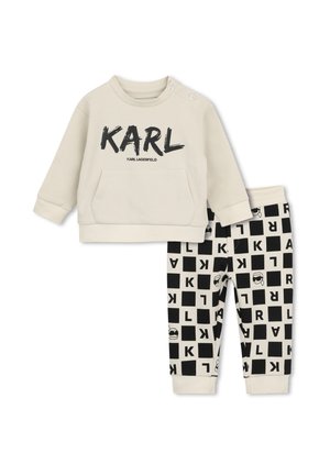 Sweat-shirt beige pour tout-petit avec "KARL" en noir et pantalon beige assorti avec motif de carrés noirs et lettres.