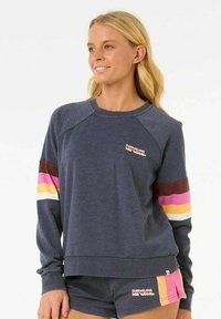 Marineblauwe sweater met raglanmouwen, met horizontale strepen in bruin, roze, geel en wit op de mouwen. Logo op de borst.