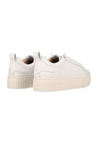 Weiße Leder-Sneaker mit flacher, profilierter Sohle, Rückziehschlaufe und seitlicher Steppnaht. Runde Zehenform und minimalistisches Design.