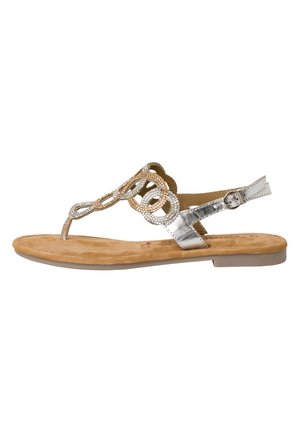 Sandales tongs métalliques argentées avec une semelle plate, dotées d'un design décoratif en perles et d'une bride de cheville réglable. Semelle intérieure en simili-suède.
