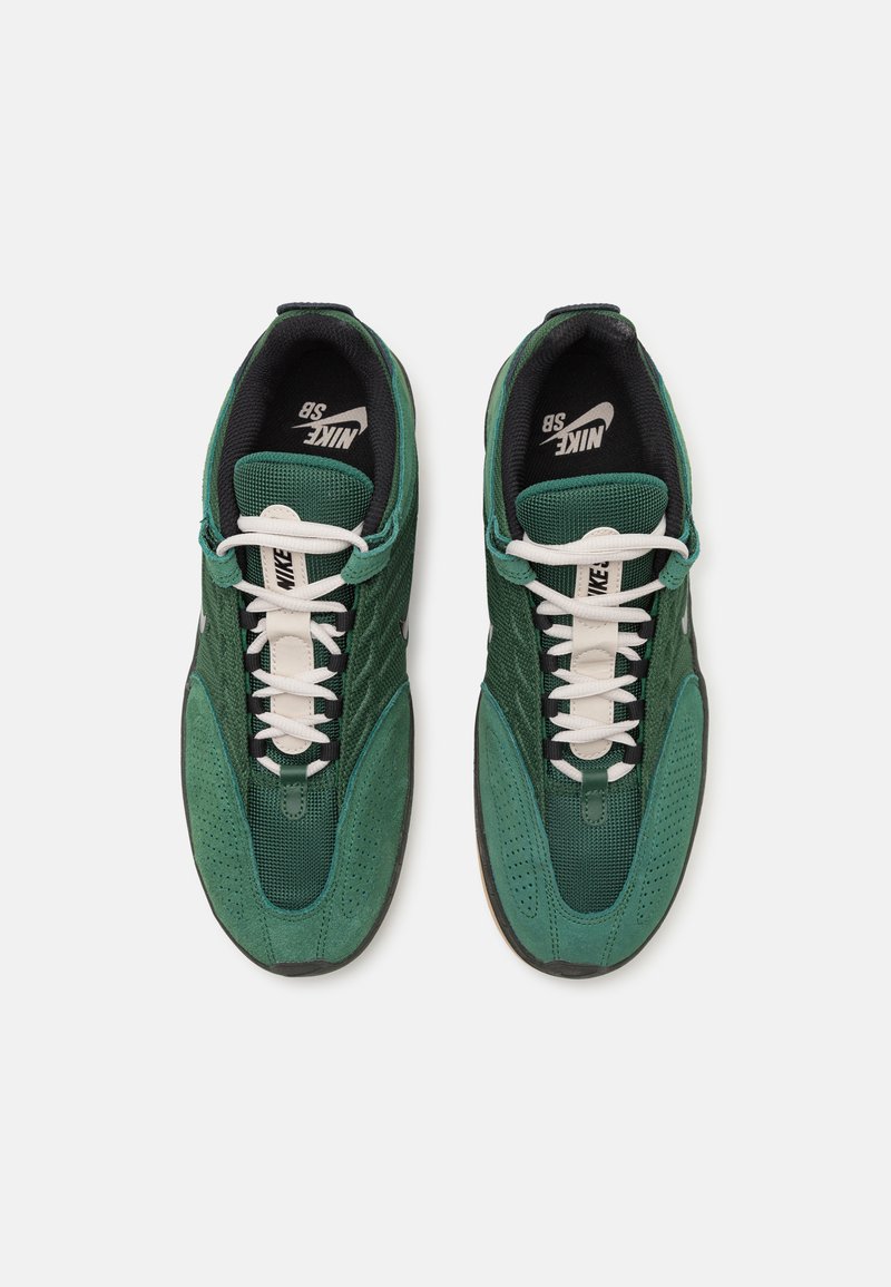 Zapatillas Nike SB verdes con una combinación de parte superior de malla y ante, cordones blancos y suela de goma, que presentan detalles perforados.