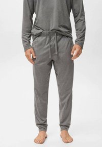 Pantalones de pijama grises hechos de material suave, con una cinturilla elástica y cordón. Piernas ajustadas y sin patrones ni piezas metálicas visibles.
