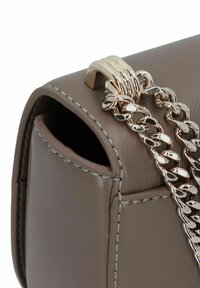 Borsa a mano in pelle marrone con una tracolla in catena dorata, caratterizzata da un evidente dettaglio in metallo dorato e cuciture visibili sui bordi.