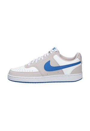 Sneaker Nike bassa in bianco e grigio chiaro con logo swoosh blu e lacci bianchi, vista laterale su sfondo bianco.