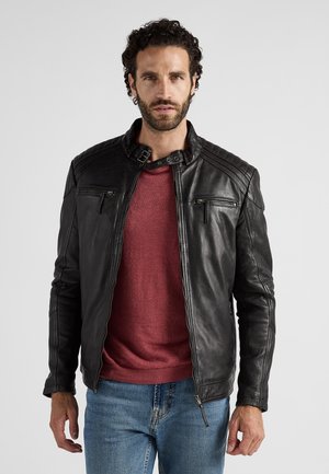 Sort læderjakke med slim fit, lynlåslukning foran, quiltede skulderdetaljer, to lynlåslommer på brystet og høj krave.