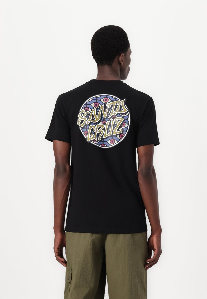 Tricou negru cu mânecă scurtă, având un grafic circular pe spate cu "SANTA CRUZ" scris într-un font stilizat și cu modele geometrice colorate.