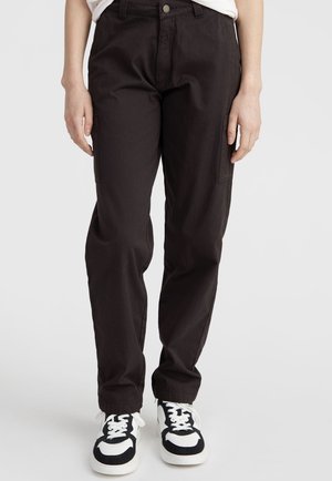 Black cargo pants with a relaxed fit, featuring side pockets and a front closure. Worn with black and white sneakers.