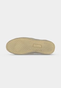 Semelle de chaussure avec un motif en forme de diamants et le nom de la marque "REPLAY" embossé près du centre en couleur beige.